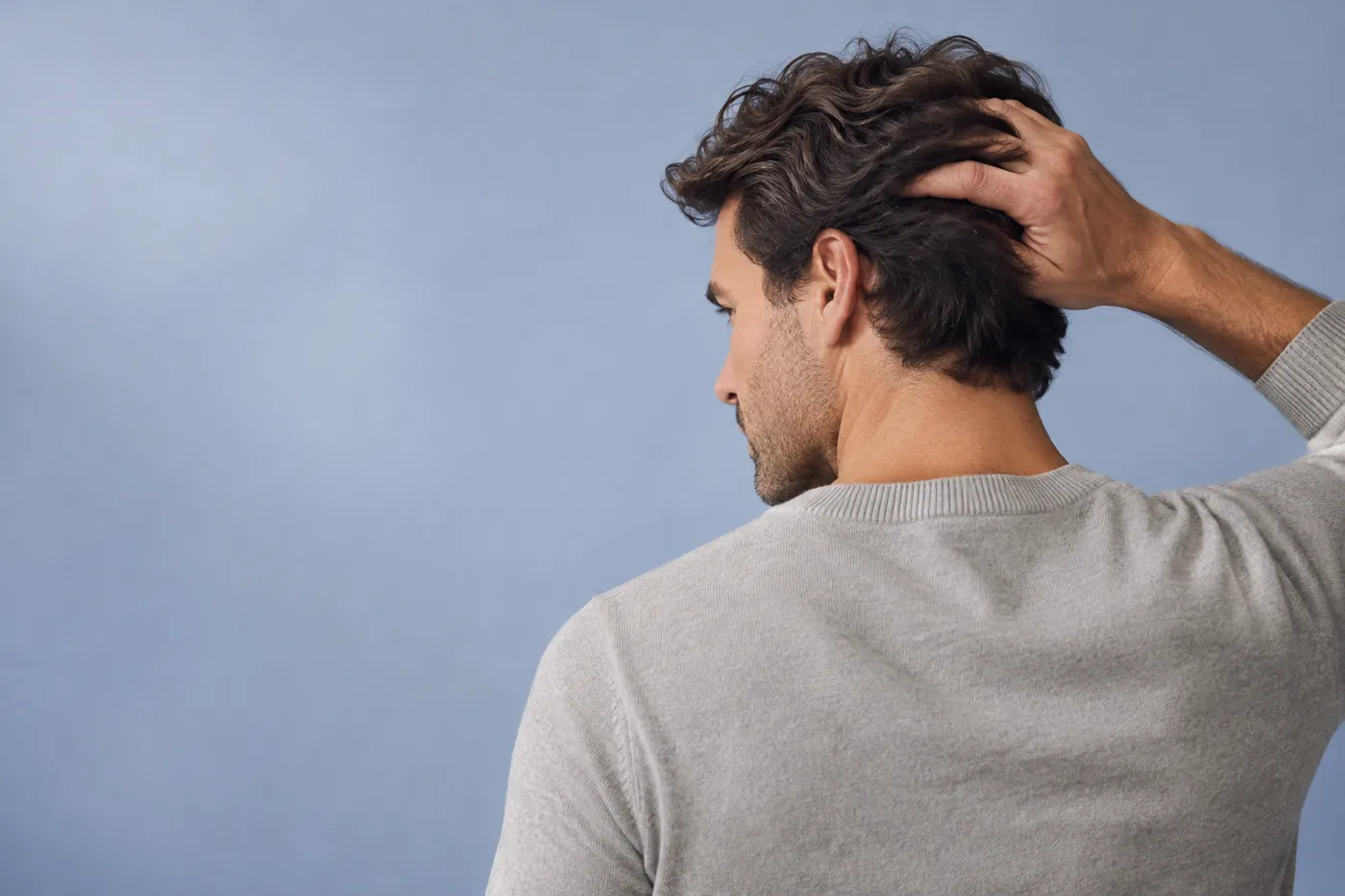 Man running his fingers through thick hair
